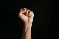 persons right hand doing fist gesture