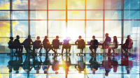 Diverse business professionals collaborating at a conference table with charts and digital devices.