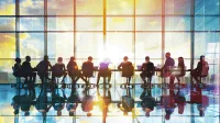 Diverse business professionals collaborating at a conference table with charts and digital devices.